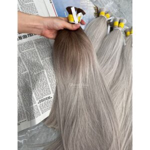 Master colorists inspecting root transitions and cuticle strength on custom Ombre blond bulk hair extensions
